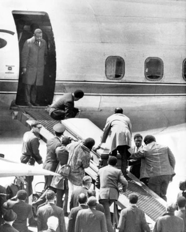 The casket bearing the body of slain civil rights leader Dr. Martin Luther King Jr., is taken up a loading ramp and placed aboard an airliner to his hometown Atlanta, Ga., on April 5, 1968, at the airport of Memphis, Tennessee. The Rev. Ralph Abernathy, King's closest associate and named to replace Dr. King as head of the SCLC, stands in the doorway of the plane.