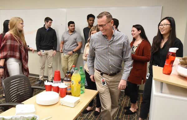 Dean Matthews (foreground), senior director of learning and development, leads a “Friendsgiving” event with college student interns from the University System of Georgia at InComm, a financial technology company, in Atlanta on Nov. 19, 2019. The interns are learning and utilizing communication skills at InComm. The University System of Georgia is working on revamping its core curriculum for the first time in two decades. The plan is to make it more flexible for 21st-century learning as more adults seek continuing education for their careers. 