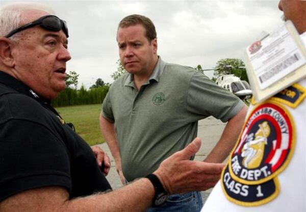 Macon/Bibb Counties EMA Director, Johnny Wingers (left) speaks with state Insurance commissioner John Oxendine after he landed in Macon Thursday.