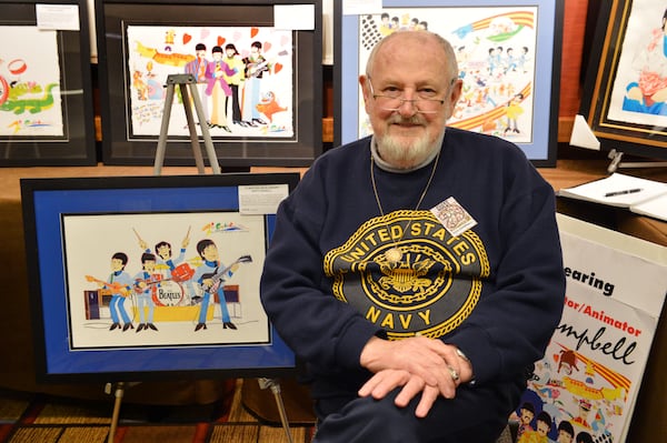 Artist Ron Campbell poses with some of his famous cartoon works.