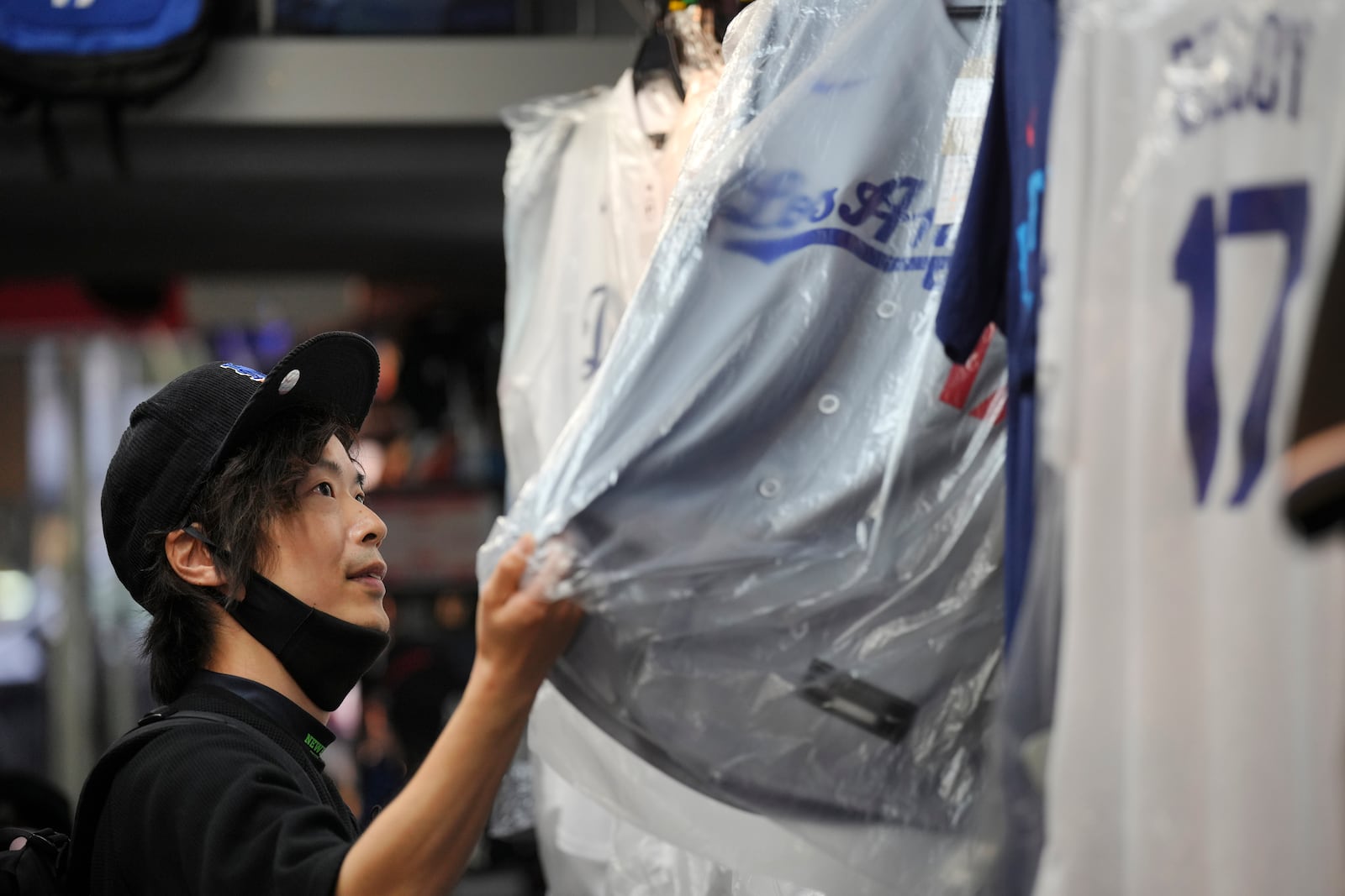 A customer Jiro Nishi, shops around for goods related to Shohei Ohtani of the Los Angeles Dodgers at a sporting goods store, "SELECTION," in Shinjuku district Wednesday, Oct. 23, 2024 in Tokyo. (AP Photo/Eugene Hoshiko)