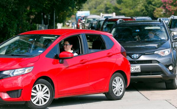 Customers line up along a busy thoroughfare to get into a QT filling station and convenience store, Thursday, Aug. 31, 2017, in Dallas. It's getting harder to fill gas tanks in parts of Texas where some stations are out of fuel and pump costs are spiking. A major gasoline pipeline shuttered due to Harvey may be able to resume shipping fuel from the Houston area by Sunday, which could ease gasoline shortages across the southern U.S.