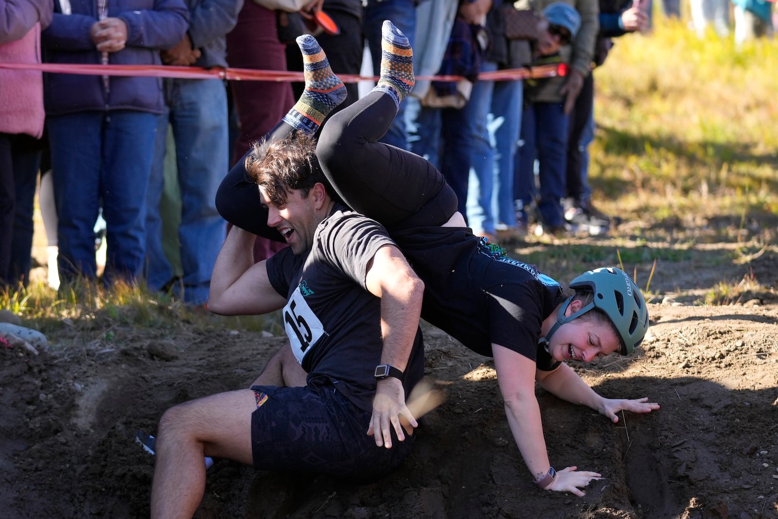 Nic Vinsonhaler looses his footing while carrying Tara Rogowski during the North American Wife Carrying Championship, Saturday, Oct. 12, 2024, at Sunday River ski resort in Newry, Maine. (AP Photo/Robert F. Bukaty)