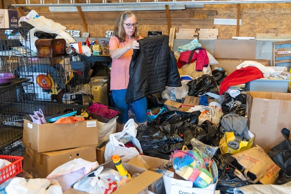 Fran Cameron looks over a mountain of clothes, toys, household appliances in the garage of her East Cobb home. PHIL SKINNER FOR THE ATLANTA JOURNAL-CONSTITUTION