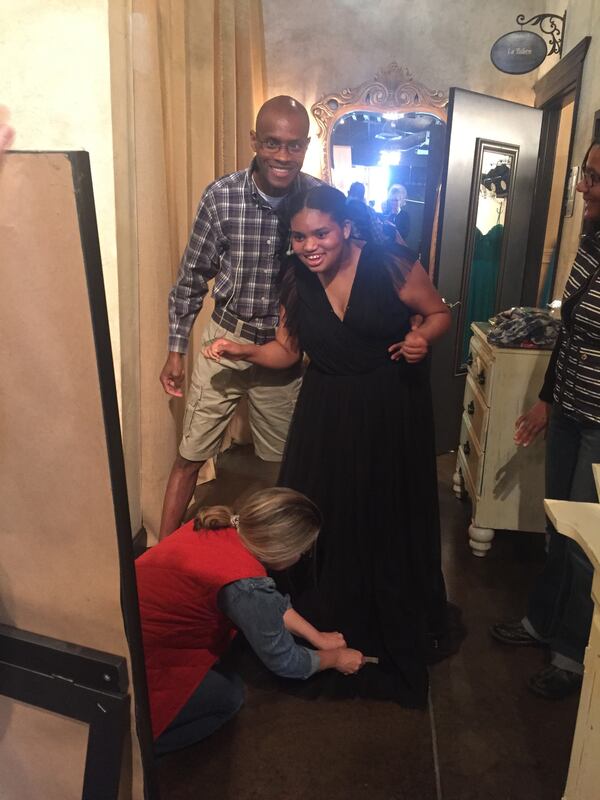 Chrissy Gordon, who is 17 years old with her father, 
Morris Gordon, smiles when she picks out a dress for the upcoming prom. 