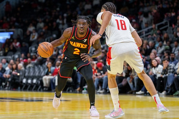 Atlanta Hawks guard Keaton Wallace (2) looks for an open teammate while guarded by Washington Wizards forward Kyshawn George (18) during the first half of an Emirates NBA Cup basketball game, Friday, Nov. 15, 2024, in Atlanta. (AP Photo/Jason Allen)