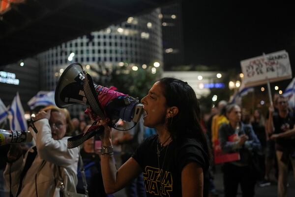 A woman shouts slogans during a protest against Prime Minister Benjamin Netanyahu's government and call for the release of hostages held in the Gaza Strip by the Hamas militant group, in Tel Aviv, Israel, Saturday, Nov. 23, 2024. (AP Photo/Maya Alleruzzo)