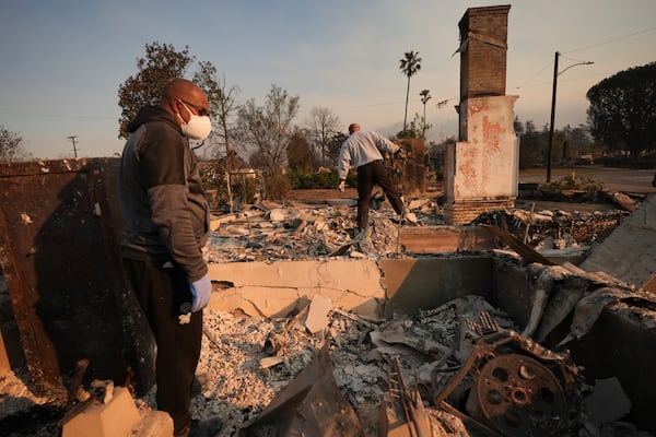 Kenneth Snowden, left, surveys the damage to his fire-ravaged property with his brother Ronnie in the aftermath of the Eaton Fire Friday, Jan. 10, 2025 in Altadena, Calif. (AP Photo/Jae C. Hong)