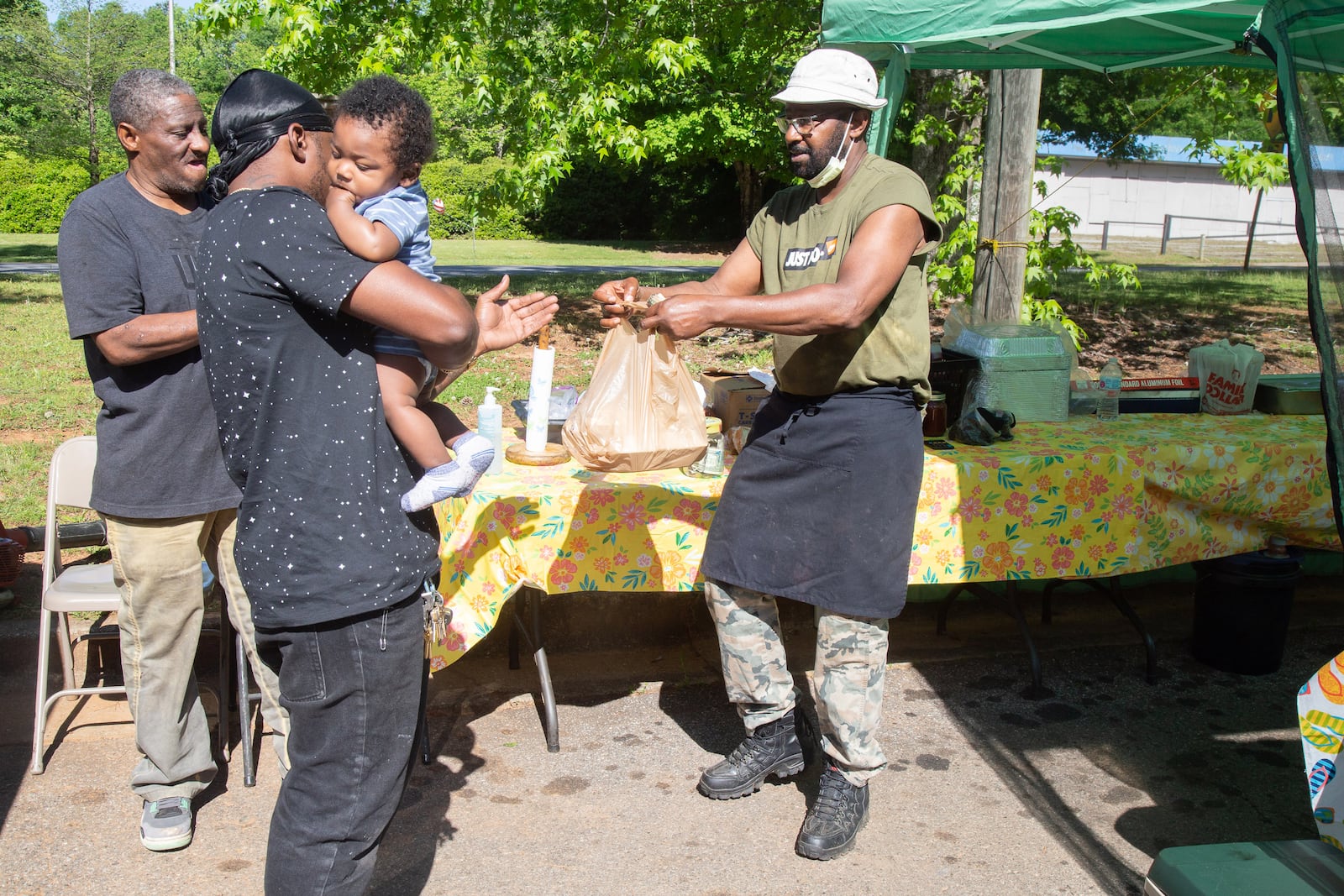 Ashton Morris and his son Ace pick up their barbecue order from Edward Spence at Spence Barbecue along Stone Hogan Connector SW in Atlanta Saturday, April 27, 2019.   STEVE SCHAEFER / SPECIAL TO THE AJC