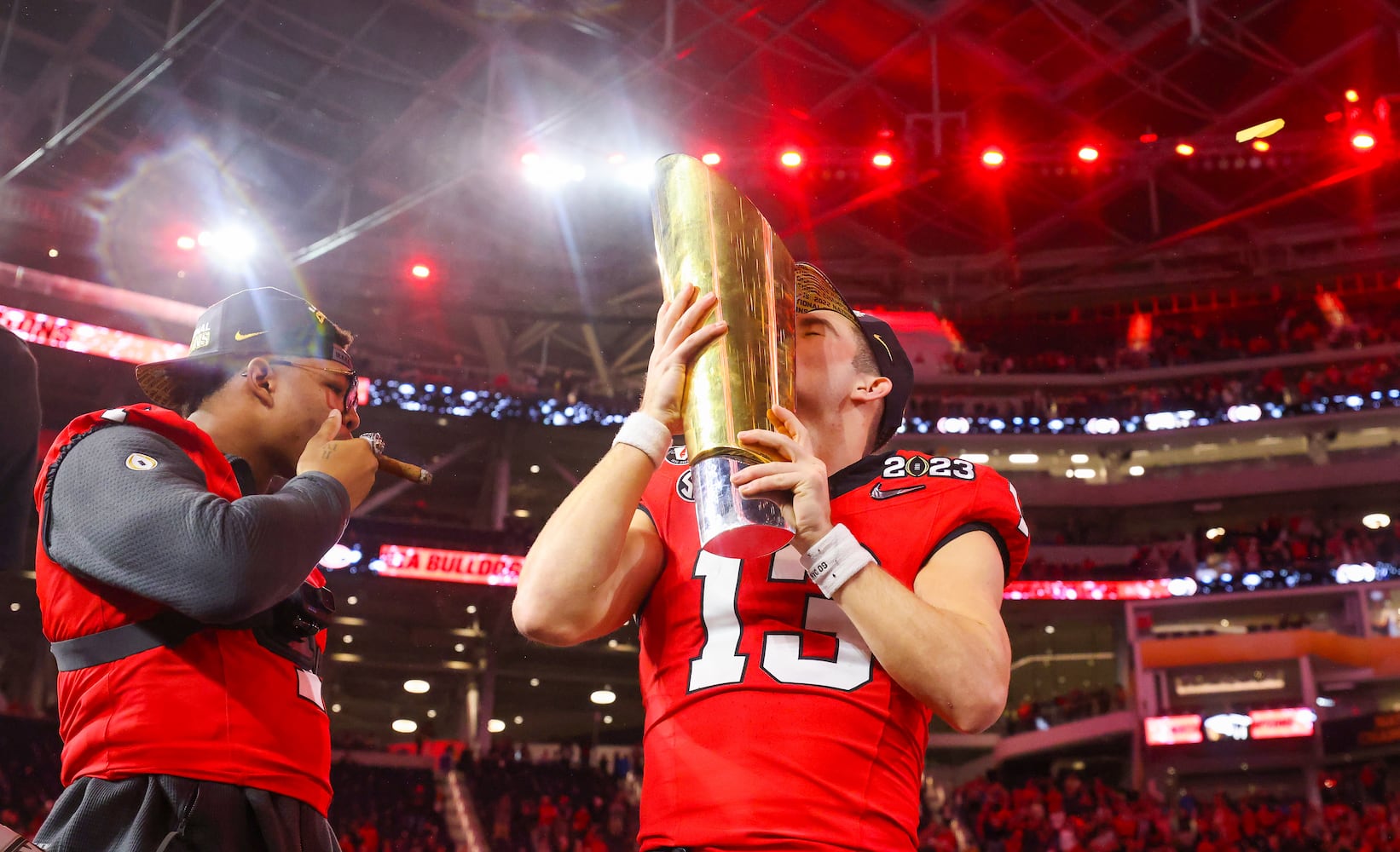 Georgia Bulldogs quarterback and offensive most valuable player Stetson Bennett (13) celebrates with the trophy after defeating the TCU Horned Frogs 65-7 in the College Football Playoff National Championship at SoFi Stadium in Los Angeles on Monday, January 9, 2023 to secure a second consecutive national title. (Jason Getz / Jason.Getz@ajc.com)