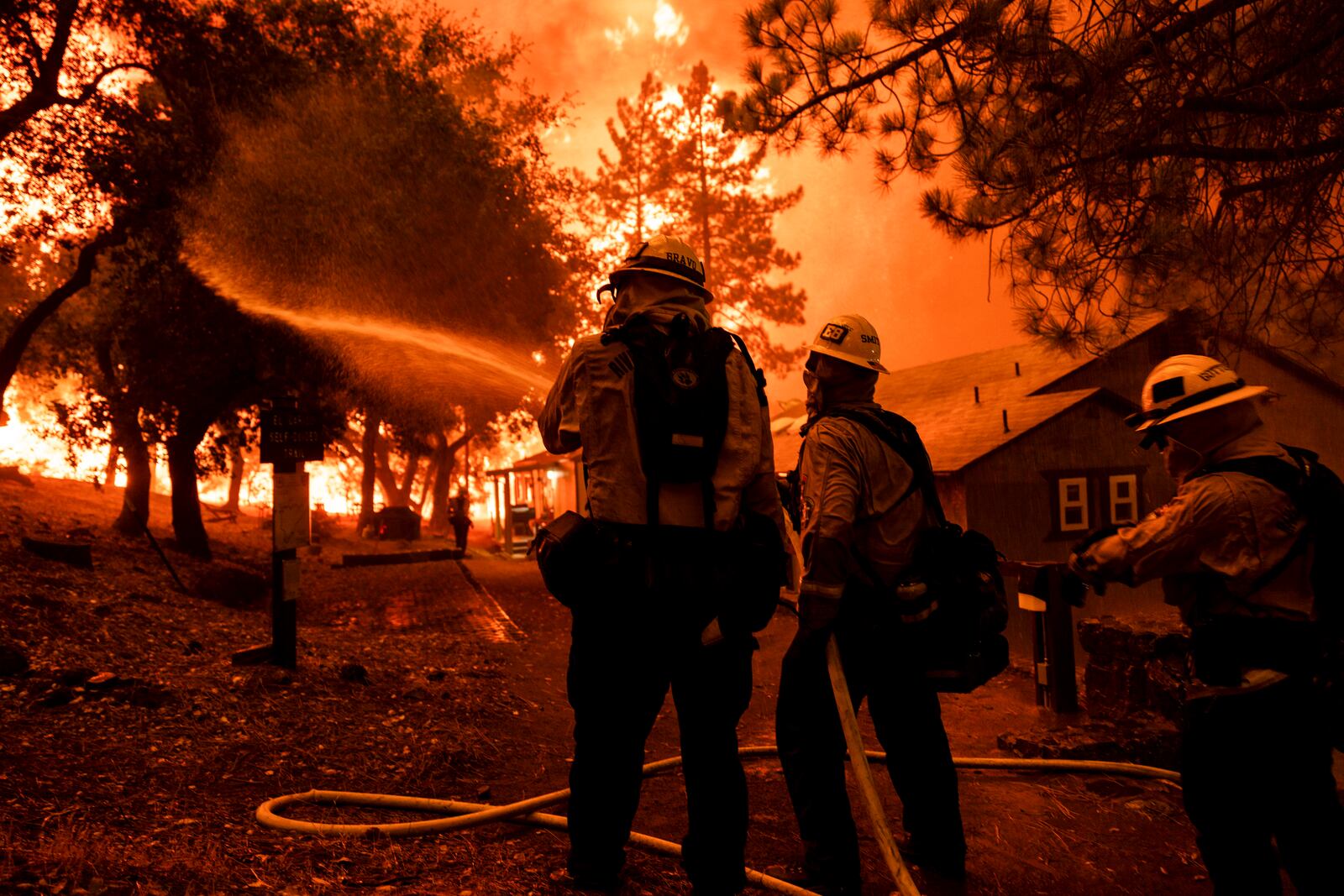 Firefighters battle the Airport Fire, Tuesday, Sept. 10, 2024, in El Cariso, an unincorporated community in Riverside County, Calif. (AP Photo/Etienne Laurent)