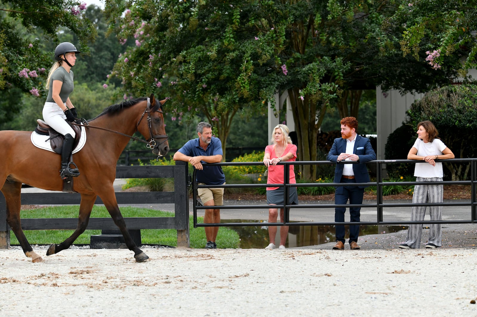 Kyle Hester (left) and his wife Cindy discuss with neighbors Ben Leonard and Christy Hayes (right) as Nicole Stringer (foreground) rides on jumping race horse Leo at Hester’s horse farm home. (Hyosub Shin / Hyosub.Shin@ajc.com)