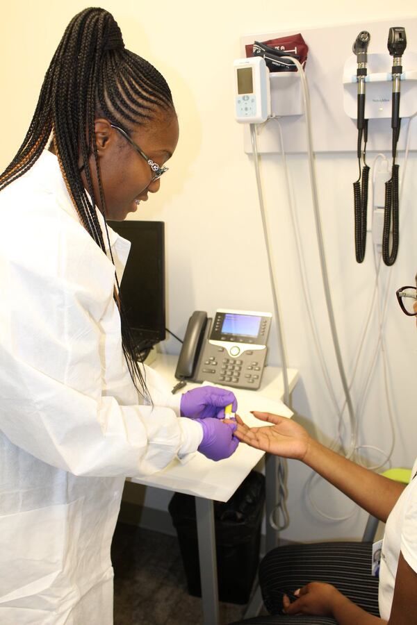 An unidentified woman gets her finger pricked for a HIV test recently in Atlanta. To end the HIV epidemic, it’s essential for people to get tested, and in care. CONTRIBUTED