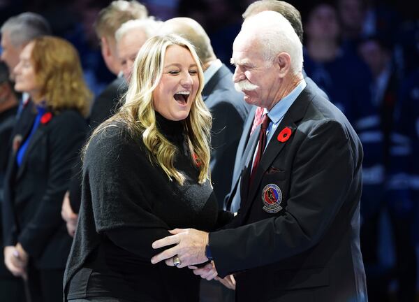 2024 Hockey Hall of Fame inductee Krissy Wendell-Pohl, left, shakes hands with Lanny McDonald, right, during a ceremony prior to NHL hockey game action between the Detroit Red Wings and the Toronto Maple Leafs in Toronto, Friday, Nov. 8, 2024. (Frank Gunn/The Canadian Press via AP)