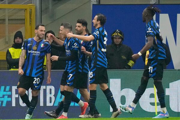 Inter Milan's Hakan Calhanoglu, left, celebrates with his teammates after scoring his side's opening goal during a Champions League opening phase soccer match between Inter Milan and Arsenal at the San Siro stadium in Milan, Italy, Wednesday, Nov. 6, 2024. (AP Photo/Luca Bruno)