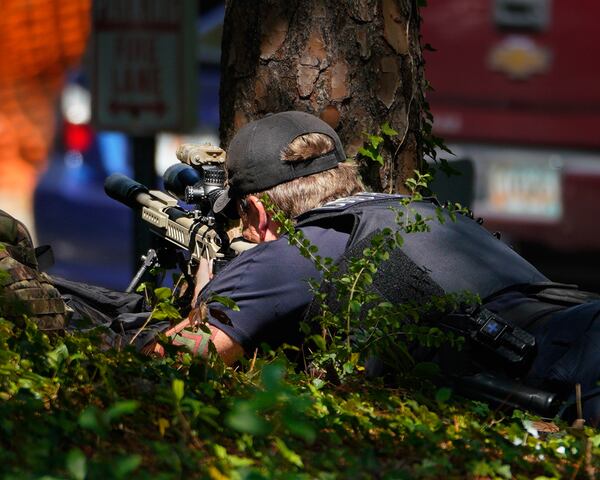 A Cobb County police officer keeps his eye on activity as SWAT officers respond to a hostage situation at the Concord Crossing Apartments.