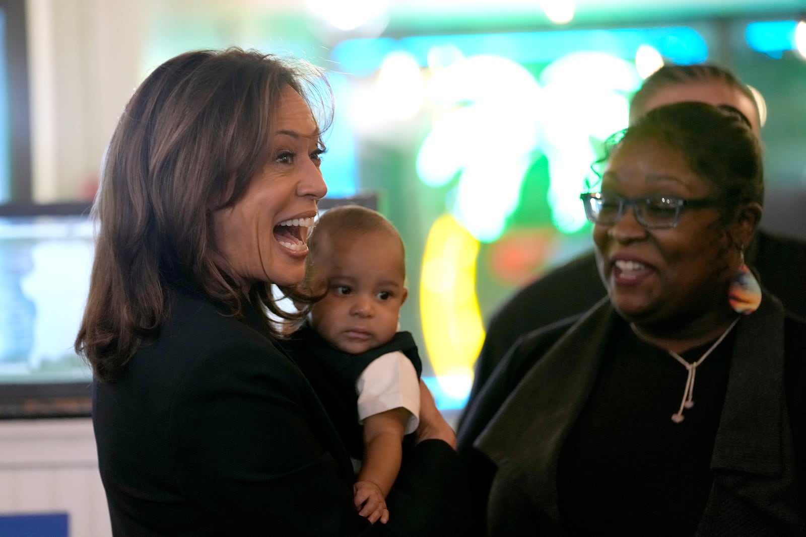 Democratic presidential nominee Vice President Kamala Harris, left, greets guests while holding a baby at Freddy and Tony's restaurant during a campaign stop, Sunday, Oct. 27, 2024, in Philadelphia. (AP Photo/Susan Walsh)