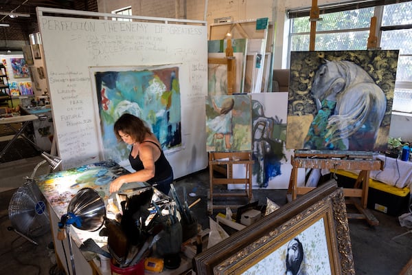 Painter Lisa Moore works in her studio in Atlanta on Friday, July 7, 2023. (Arvin Temkar / arvin.temkar@ajc.com)