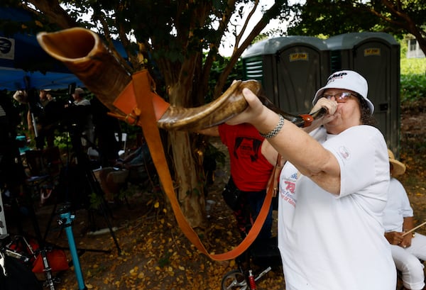 Pat Kahl, a Louisiana supporter of Donald Trump, performs with a Shofar outside of the Fulton County Jail as a growing crowd waits for Donald Trump’s arrival. (Miguel Martinez / miguel.martinezjimenez@ajc.com)