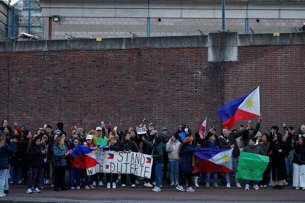 Supporters of former Philippine President Rodrigo Duterte hold flags and banners during a demonstration outside the International Criminal Court detention center near The Hague in Scheveningen, Netherlands, Wednesday, March 12, 2025. (AP Photo/Omar Havana)