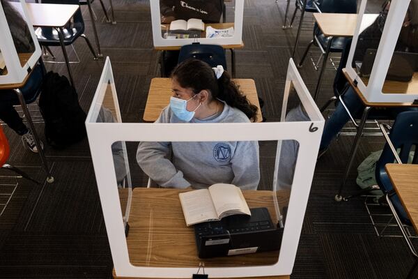 201105-Marietta-Monserrath Guerrero works behind a plastic partition during her language arts class at Marietta Middle School on Thursday afternoon, Nov. 5, 2020. Even though there are only five students in the room during class, they all wear masks and sit behind plastic partitions. Ben Gray for the Atlanta Journal-Constitution