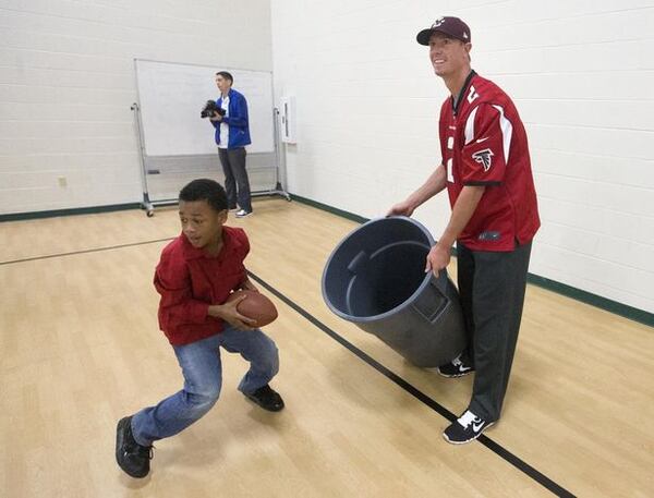 Atlanta Falcons quarterback Matt Ryan (2) A student at Venetian Hills Elementary plays with Atlanta Falcons quarterback Matt Ryan (2) as part of the NFL's Play 60 physical fitness as part of the initiative Tuesday, Oct. 14, 2014, in Atlanta. In October 2007, the NFL launched NFL Play 60, a national youth health and fitness campaign focused on increasing the wellness of young fans by encouraging them to be active for at least 60 minutes a day. (AP Photo/John Bazemore)