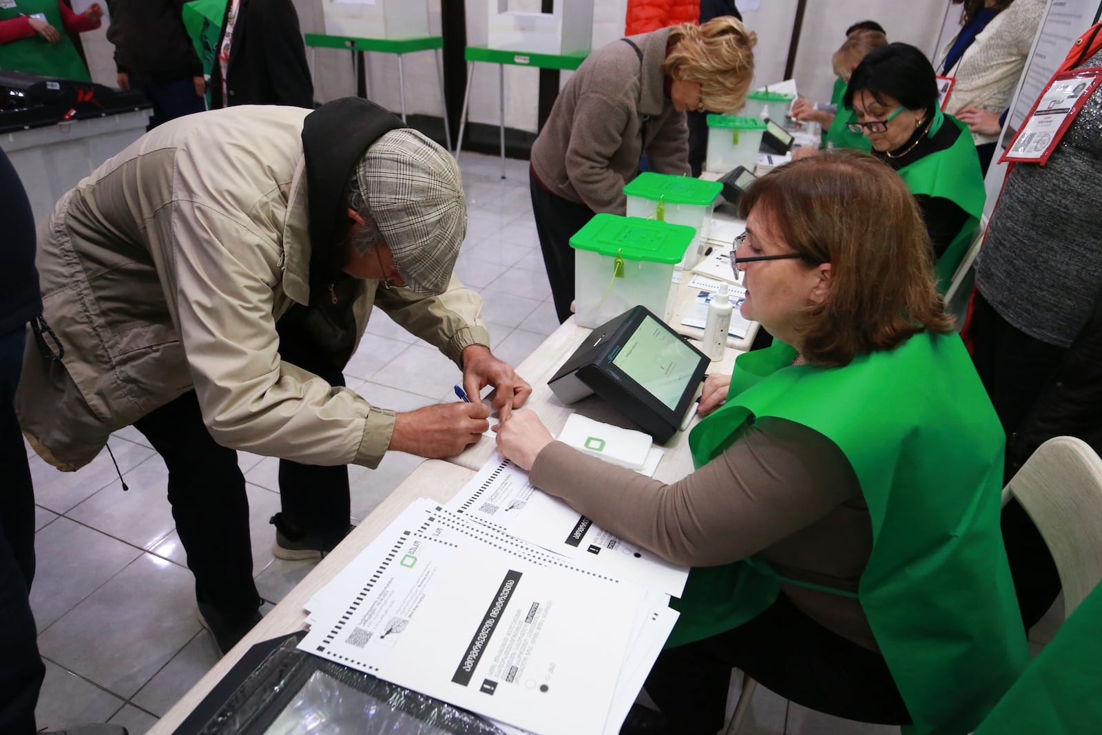 People get their ballots at a polling station during the parliamentary election in Tbilisi, Georgia, Saturday, Oct. 26, 2024. (AP Photo/Zurab Tsertsvadze)