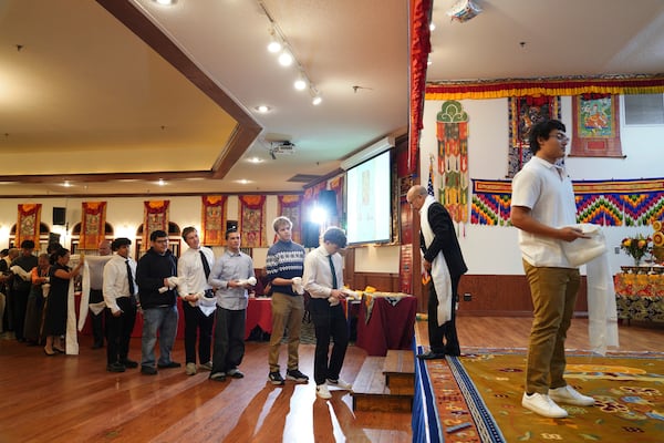 High school friends and fellow football players line up to present U.S.-born Buddhist lama, Jalue Dorje, with “khata,” the Tibetan ceremonial scarves that symbolize auspiciousness, at his 18th birthday and enthronement ceremony, in Isanti, Minn., on Saturday, Nov. 9, 2024. (AP Photo/Jessie Wardarski)