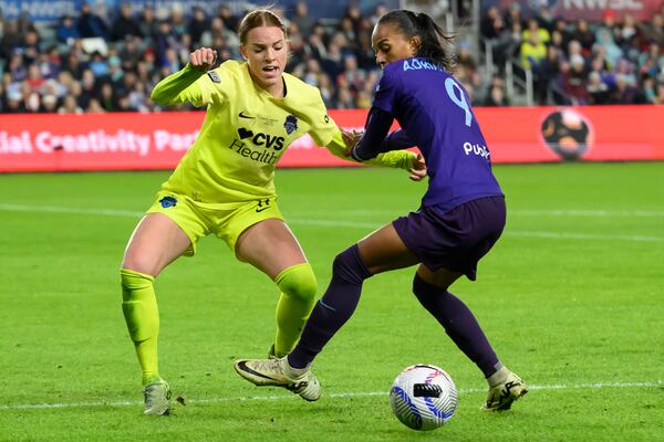 Washington Spirit midfielder Hal Hershfelt, left, and Orlando Pride forward Adriana (9) battle for control of the ball during the second half of the NWSL championship soccer game at CPKC Stadium, Saturday, Nov. 23, 2024, in Kansas City, Mo. (AP Photo/Reed Hoffmann)