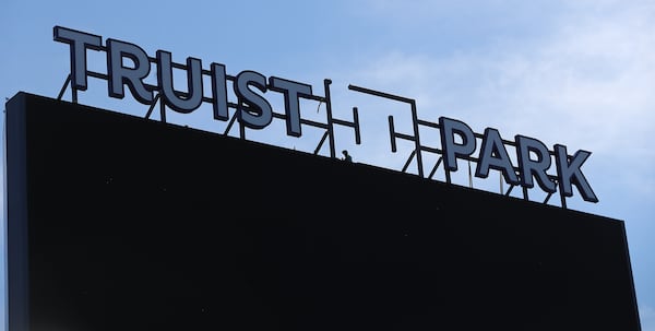  A constuction worker installs the new sign over the center -field scoreboard/video board at newly renamed Truist Park.  