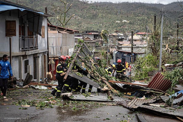 This photo provided on Monday Dec. 16, 2024 by the Civil Security shows rescue workers clearing a street in French territory of Mayotte in the Indian Ocean, after the island was battered by its worst cyclone in nearly a century. (UIISC7/Securite Civile via AP)