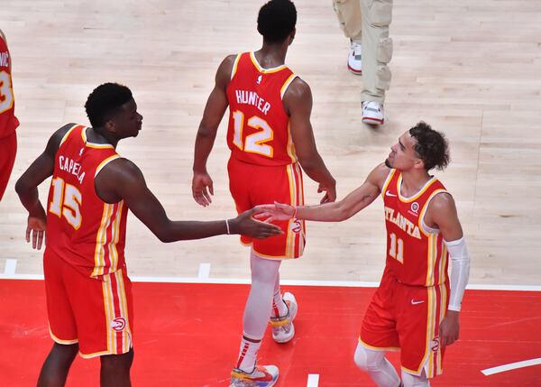 Hawks center Clint Capela (15) and guard Trae Young (11) cometogether after a key play in the win. (Hyosub Shin / Hyosub.Shin@ajc.com)