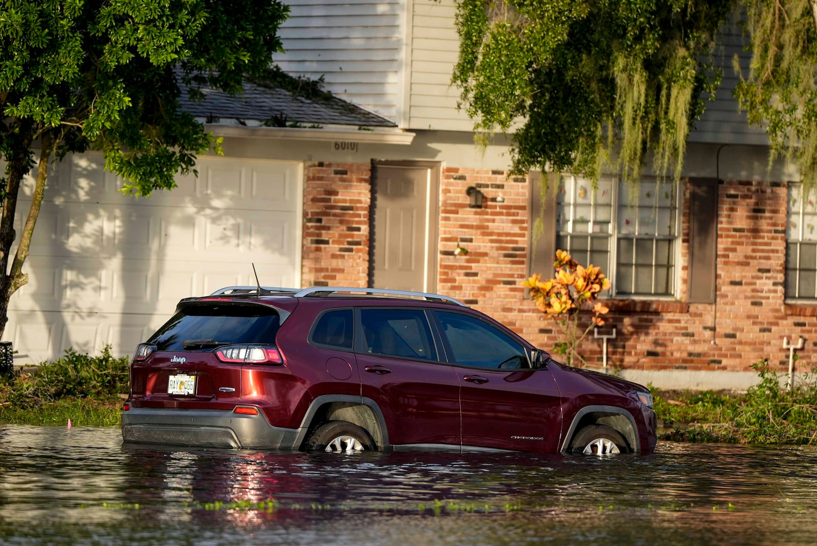 A car sits in high water in front of a home in the aftermath of hurricane Milton, Thursday, Oct. 10, 2024, in Tampa, Fla. (AP Photo/Mike Stewart)