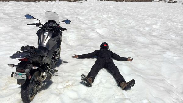 We didn&apos;t expect to see snow in July, even at 12,000 feet. Abhi expressed his enthusiasm by riding the Kawasaki directly into a drift, then lying down next to it. (Charles Fleming/Los Angeles Times/TNS)