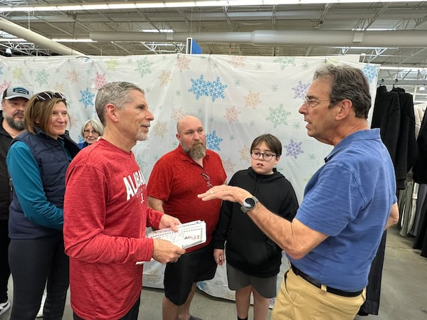 Clark Howard provides travel advice to Jack Frank of Milton (left) and Jason Rochester and his son Ashton at the Clark's Christmas Kids event at the Roswell Walmart Dec. 8, 2024. RODNEY HO/rho@ajc.com