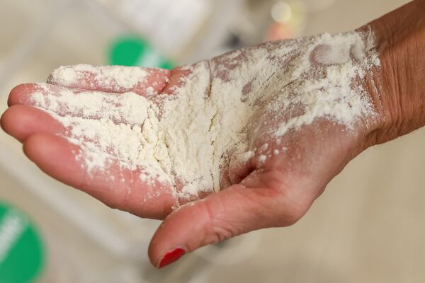 Julie Allen, 47, from Athens, Georgia is the founder and coordinator of the #BakeWithMe project which connects bakers from the Athens community to make and donate bread for those in need. Allen scoops flour for a photo inside of Earth Fare in Athens, Georgia on Monday, Nov. 6, 2023.  (Photo Courtesy of Samantha Hurley)