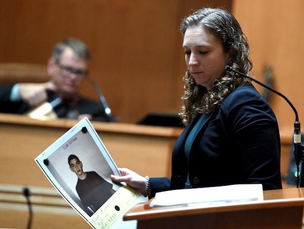 Assistant Attorney General Audriana Mekula holds a picture of alleged victim Michael Gilpatrick when he was 14 that she showed the jury during opening statements in the trial of Bradley Asbury at Hillsborough County Superior Court in Manchester, N.H.,, Tuesday, Nov. 19, 2024. (David Lane/Union Leader via AP, Pool)