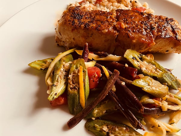 Pan-roasted halibut, served with holy trinity risotto, smoky tomato sauce and a side of sautéed vegetables, is available from Serpas True Food. Bob Townsend for The Atlanta Journal-Constitution