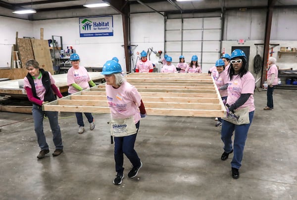 FILE - Volunteers carry a newly-constructed wall section inside the Habitat for Humanity Owensboro's indoor workshop, Jan. 13, 2024, in Owensboro, Ky. (Greg Eans/The Messenger-Inquirer via AP, File)