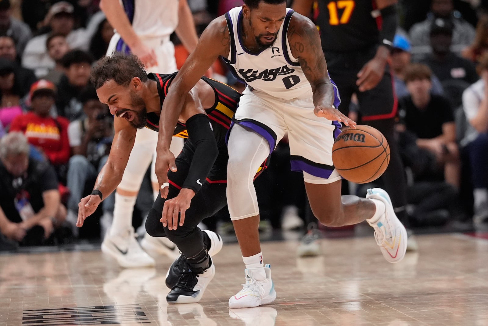 Atlanta Hawks guard Trae Young (11) tries to steal the ball from Sacramento Kings guard Malik Monk (0) during the first half of an NBA basketball game, Friday, Nov. 1, 2024, in Atlanta. (AP Photo/ John Bazemore )