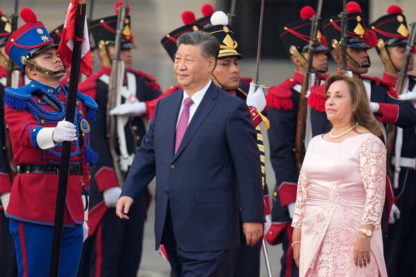 China's President Xi Jinping, center, and Peru's President Dina Boluarte face the honor guard during a welcome ceremony at the government palace in Lima, Peru, Thursday, Nov. 14, 2024, on the sidelines of the Asia-Pacific Economic Cooperation (APEC) summit. (AP Photo/Fernando Vergara)