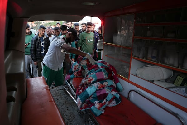 A Palestinian paramedic checks a body of a person killed during an Israeli bombardment in Nuseirat, central Gaza, at a hospital morgue in Deir al-Balah, Gaza Strip, Wednesday, Nov. 20, 2024. (AP Photo/Abdel Kareem Hana)