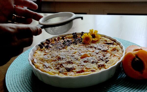 Dusting an Apricot Almond Calfouti with powdered sugar. (Pam Panchak/Pittsburgh Post-Gazette/TNS)