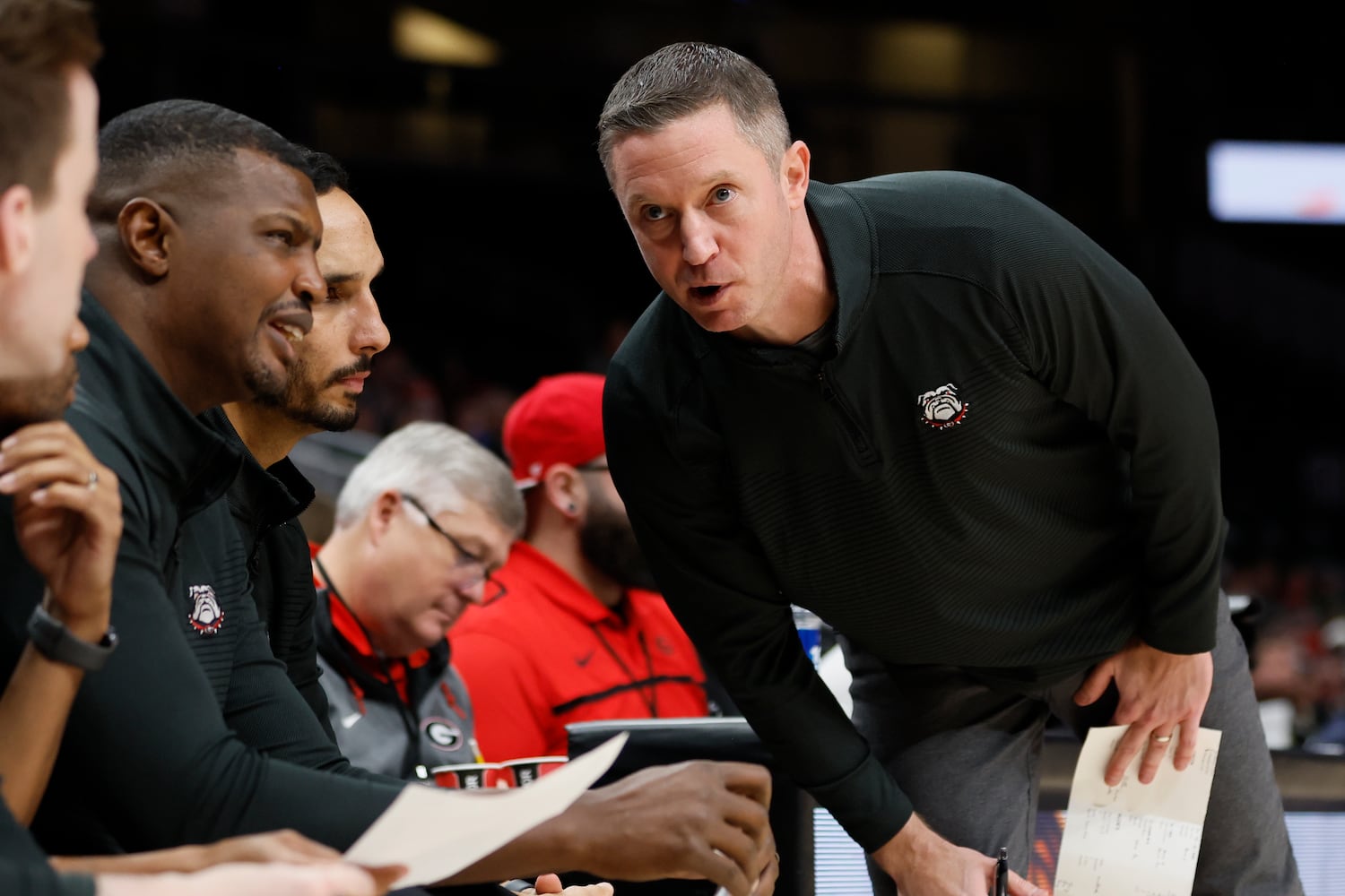 Bulldogs coach Mike White talks with his assistants during the second half Sunday night at State Farm Arena. (Miguel Martinez / miguel.martinezjimenez@ajc.com)