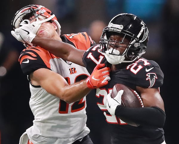 Falcons safety Damontae Kazee stiff arms Cincinnati Bengals wide receiver Alex Erickson while intercepting quarterback Andy Dalton during the third quarter Sunday, Sept 30, 2018, in Atlanta. 