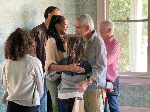 Kysha Hehn hugs Farrow Allen, the grandson of Luther Judson Price. Price built the home in the 1890s. Hehn and her husband Jonathan purchased the home seven years ago and are in the process of renovating it. Hehn says she wants the house "to be a place of holding memory and preserving legacy. That is a responsibility that we hold,” she said. NEDRA RHONE/ NEDRA.RHONE@AJC.COM