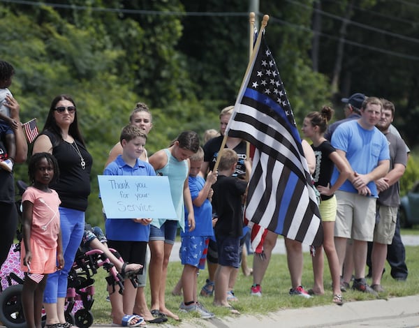 July 11, 2019, Gainesville — Spectators carried signs and flags as they waited for the funeral procession to leave the church for burial. A funeral service was held for slain Hall County Sheriff’s Deputy Nicolas Blane Dixon, the fourth Georgia law enforcement officer killed in the line of duty this year. The service was held at Free Chapel Worship Center in Gainesville. Bob Andres / bandres@ajc.com