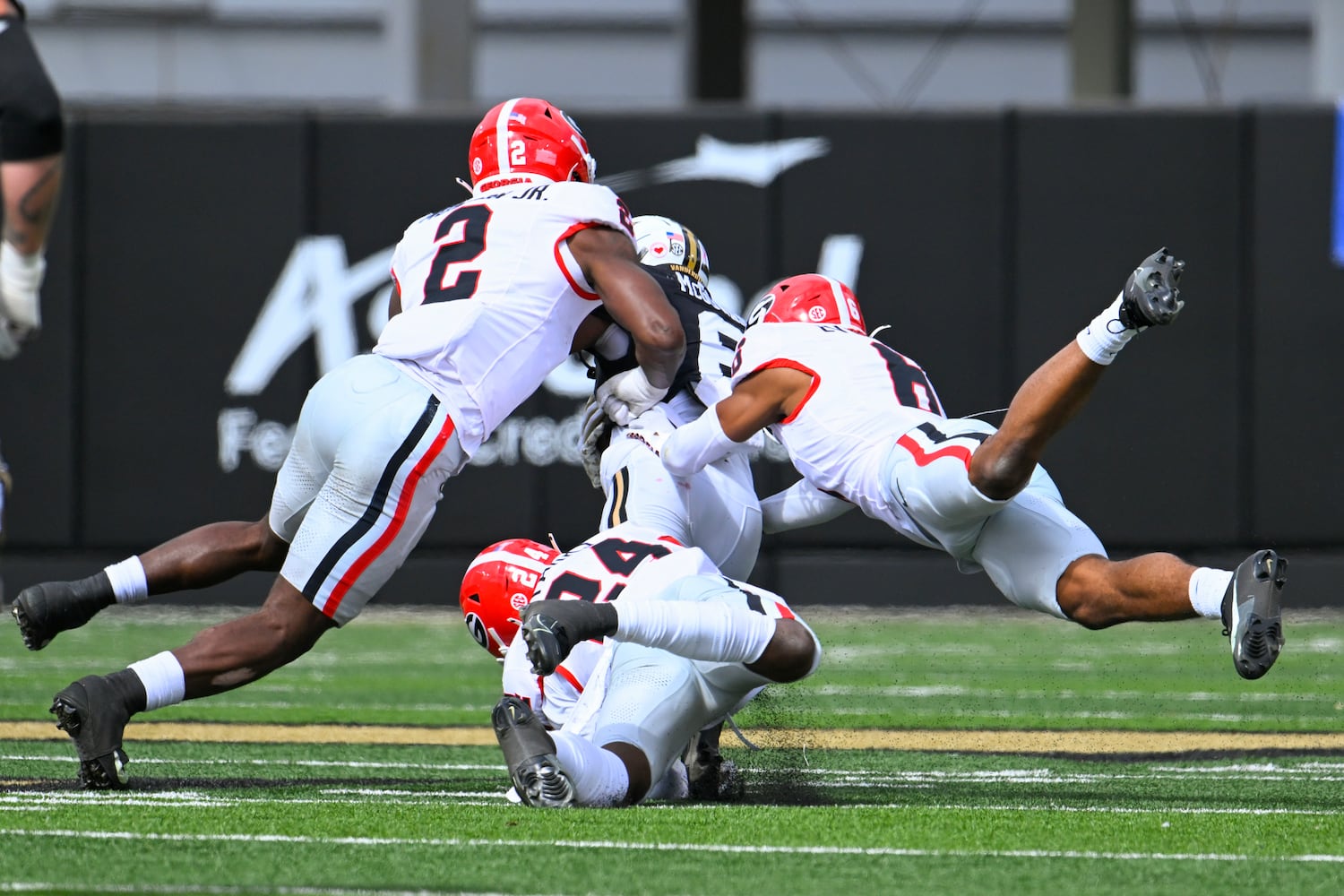 Georgia linebacker Smael Mondon Jr. (2), defensive back Malaki Starks (24), and defensive back Daylen Everette (6) tackle Vanderbilt wide receiver Jayden McGowan (6) during the second half of an NCAA football game against Vanderbilt, Saturday, Oct. 14, 2023, in Nashville, Tenn. Georgia won 37-20. (Special to the AJC/John Amis)