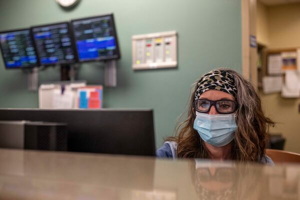 Tanner Health System overflow nurse manager Paula Liles organizes a list of patients as she prepares to move patients to different rooms in the emergency department at the Carrollton hospital. (Alyssa Pointer / Alyssa.Pointer@ajc.com)