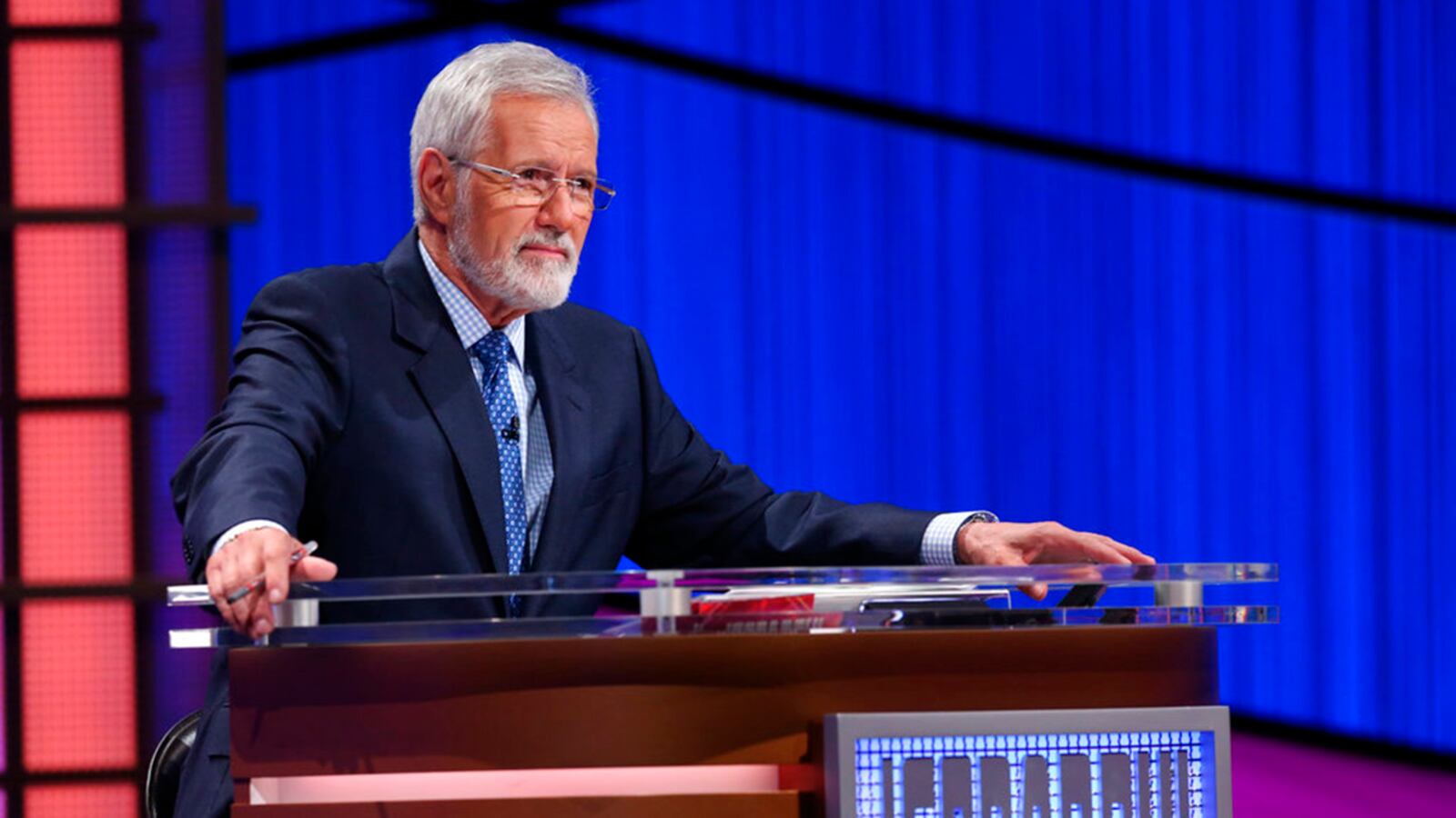 This July 17, 2018 image released by Jeopardy Productions shows host Alex Trebek sporting a beard during a taping of "Jeopardy!" in Culver City, Calif. Trebek sported a beard as he launched the 35th season of "Jeopardy!" and the look has led to a poll. (Carol Kaelson/Jeopardy Productions via AP)